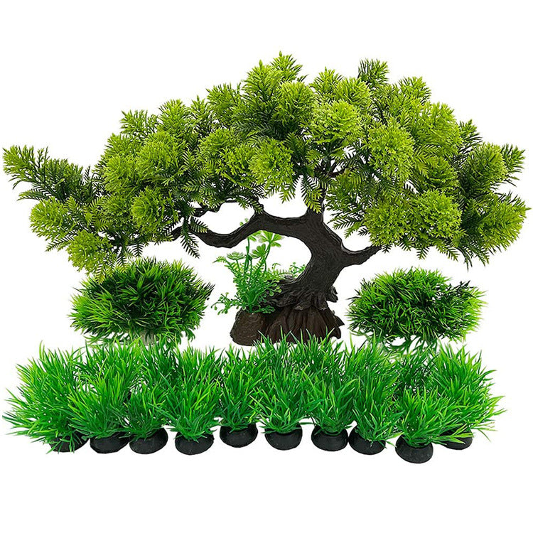 Artificial bonsai tree with smaller trees and grass on a white background