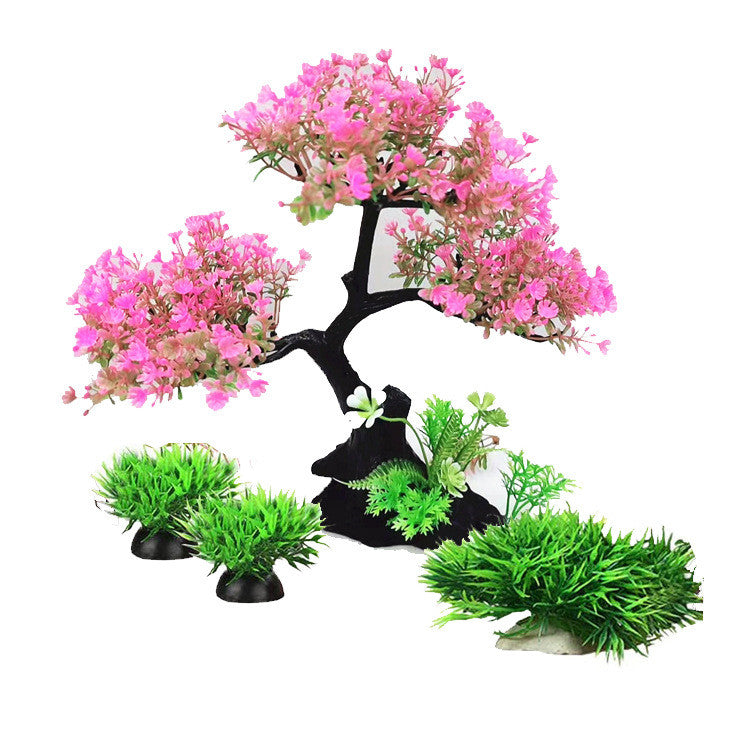 Artificial bonsai tree with pink flowers and green plants on a white background