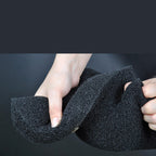 Black foam finger held by a person against a dark background