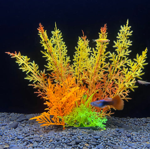 Artificial aquarium plants with orange, green, and red hues on a dark background