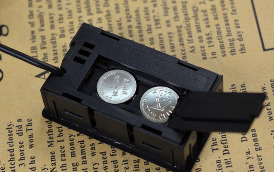 Black coin holder with two silver coins on a textured paper background